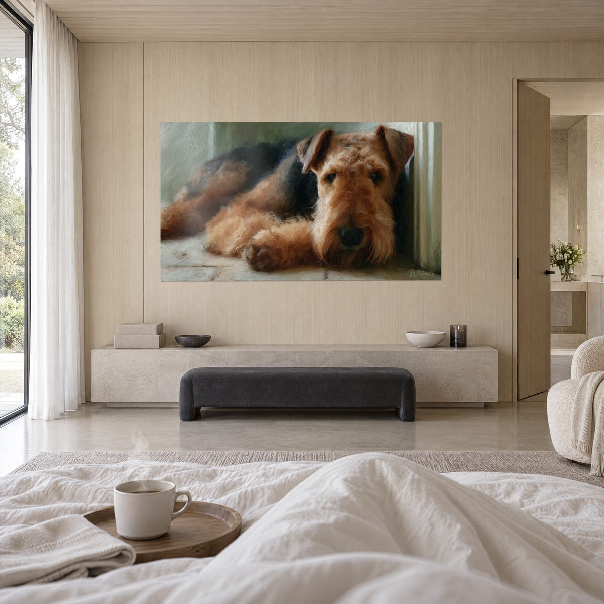 Cuadro terrier cachorro tumbado, mirada tierna, pelaje caramelo y negro, persona de espaldas, encima de una cama en un dormitorio luminoso