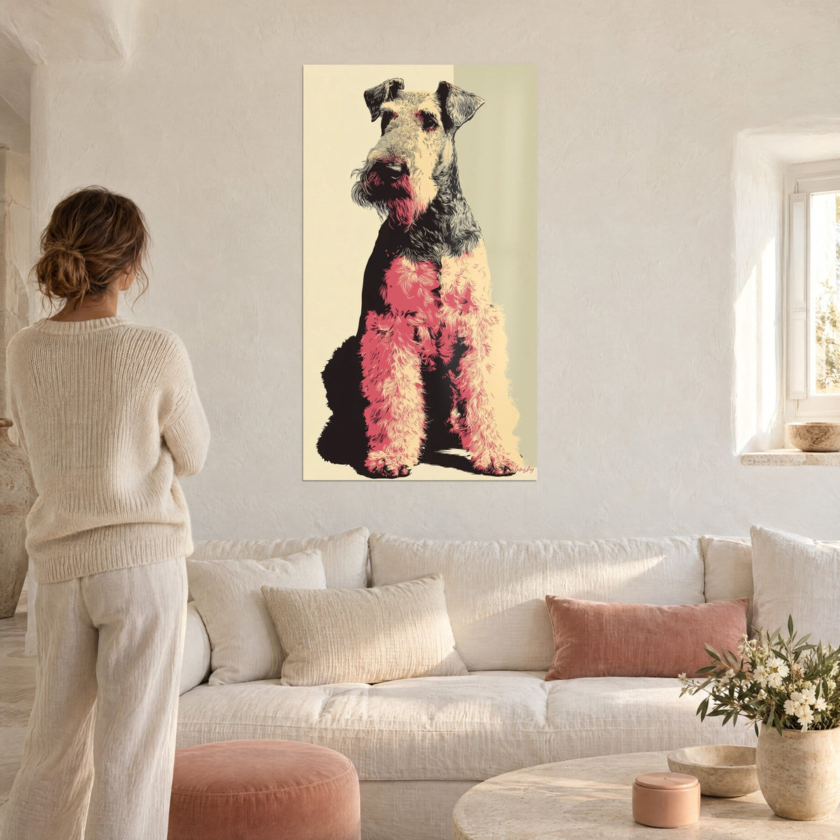 Cuadro airedale terrier sentado, pelaje rosa coral y negro sobre fondo crema, encima de un sofá en un salón luminoso
