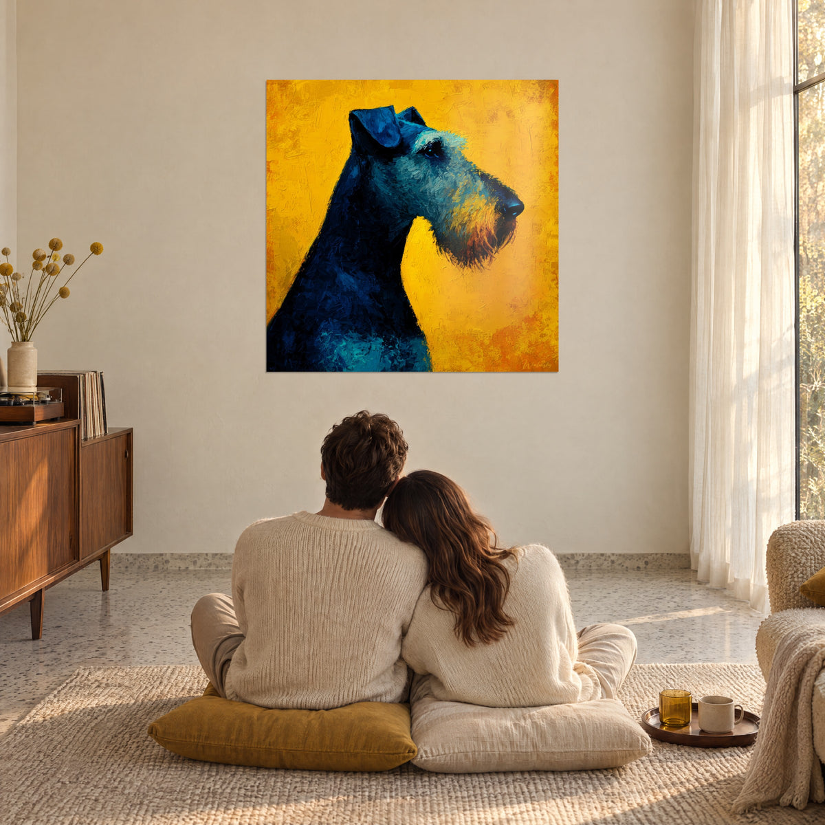 Cuadro silueta canina azul marino sobre amarillo brillante, hocico negro brillante, frente a una pareja sentada en el suelo sobre cojines