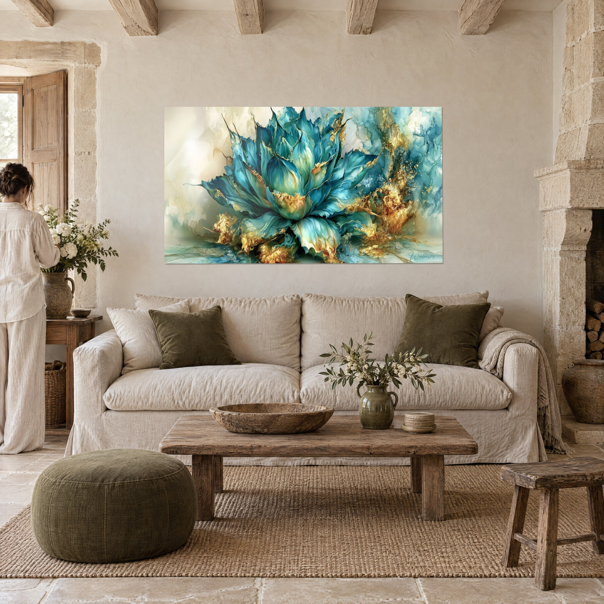Wall art blue-green agave with gold-tipped tapering petals, two people seen from behind, above a sofa in a bright living room