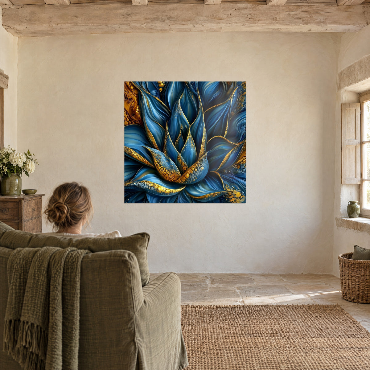 Tableau corolle bleu céruléen aux bordures d'or martelé, une femme de dos dans un fauteuil vert face au mur de chaux