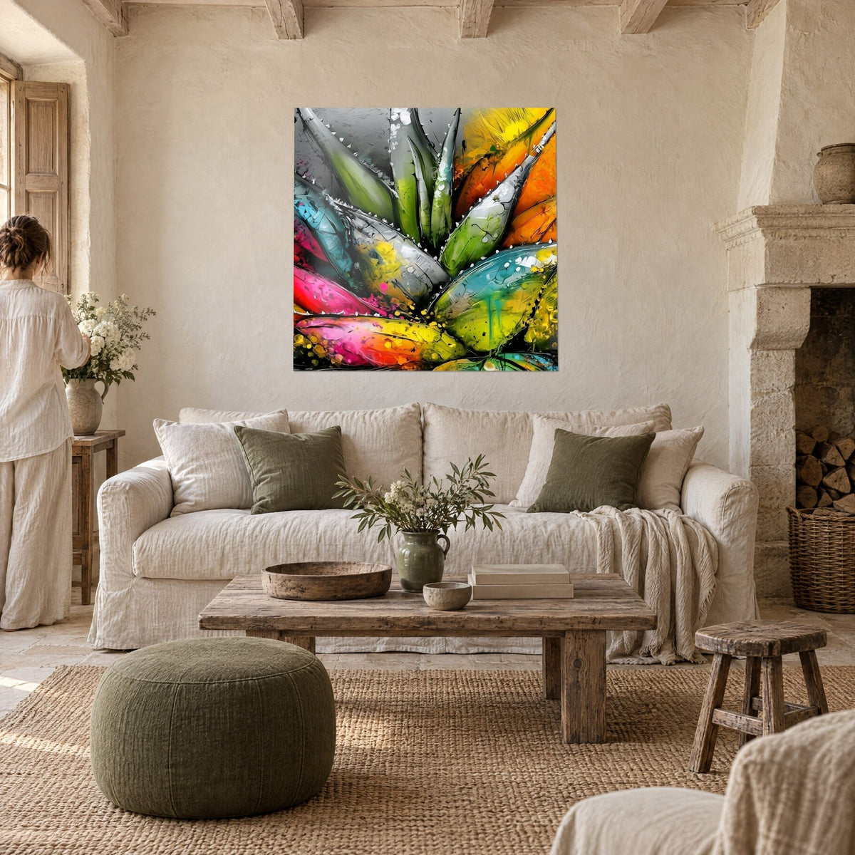 Quadro aloe con foglie verde menta e fucsia ricoperte di gocce, visto di spalle da una donna sopra un divano in un soggiorno luminoso