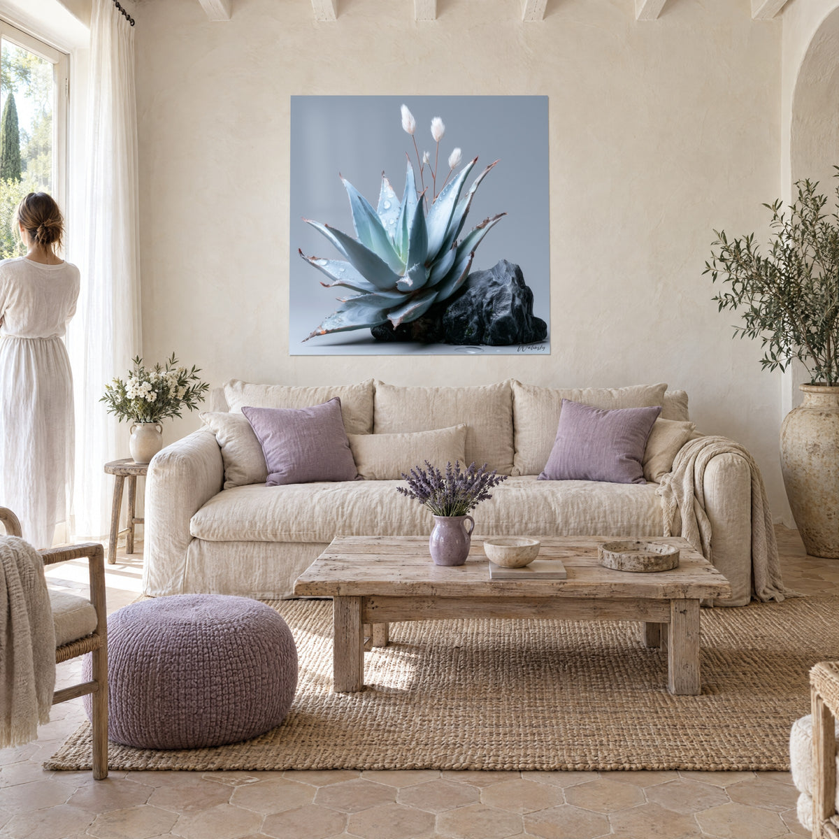 Tableau agave bleu givré aux feuilles piquetées de rosée sur roche noire, mur crème, au-dessus d'un canapé dans un salon lumineux