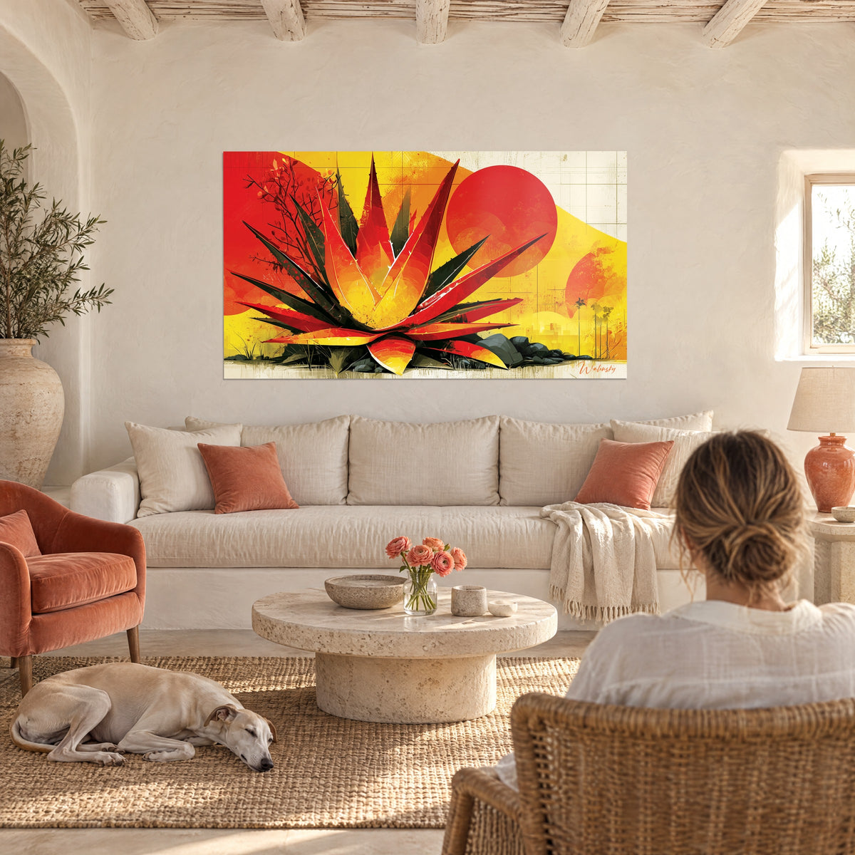 Tableau aloès aux feuilles pointues rouges et noires sur fond jaune, soleil rouge, au-dessus d'un canapé dans un salon lumineux