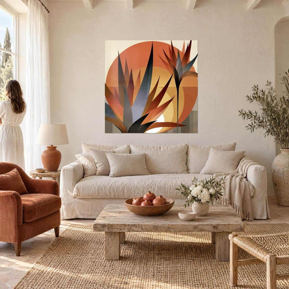 Wall art with slender agave leaves in slate grey and terracotta in front of an orange sun, above a sofa in a bright living room