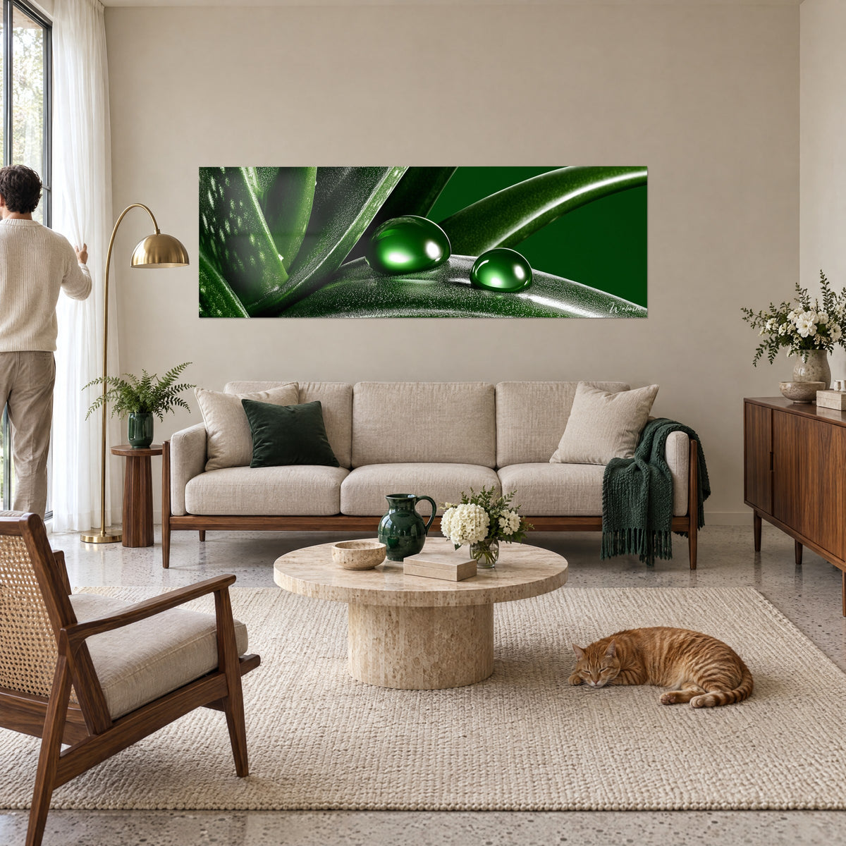 Tableau aloès aux gouttes bombées vert émeraude sur fond noir, homme de dos et chat roux, au-dessus d'un canapé dans un salon lumineux