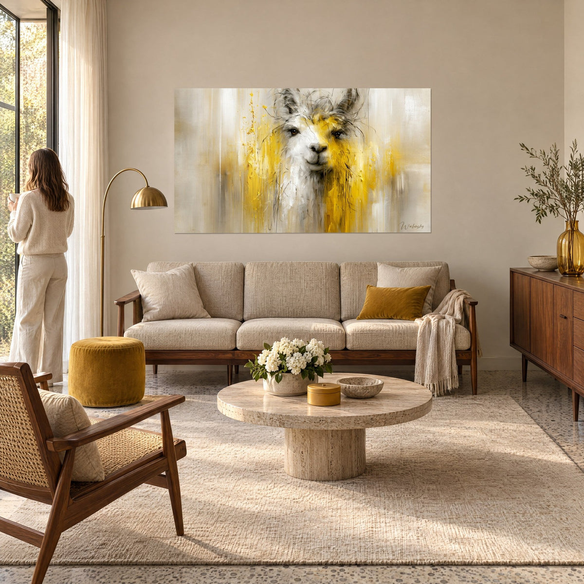 Gemälde Lama mit weißem Fell und senfgelben Laufspuren, goldene Spritzer auf beigem Grund, über einem Sofa in einem hellen Wohnzimmer