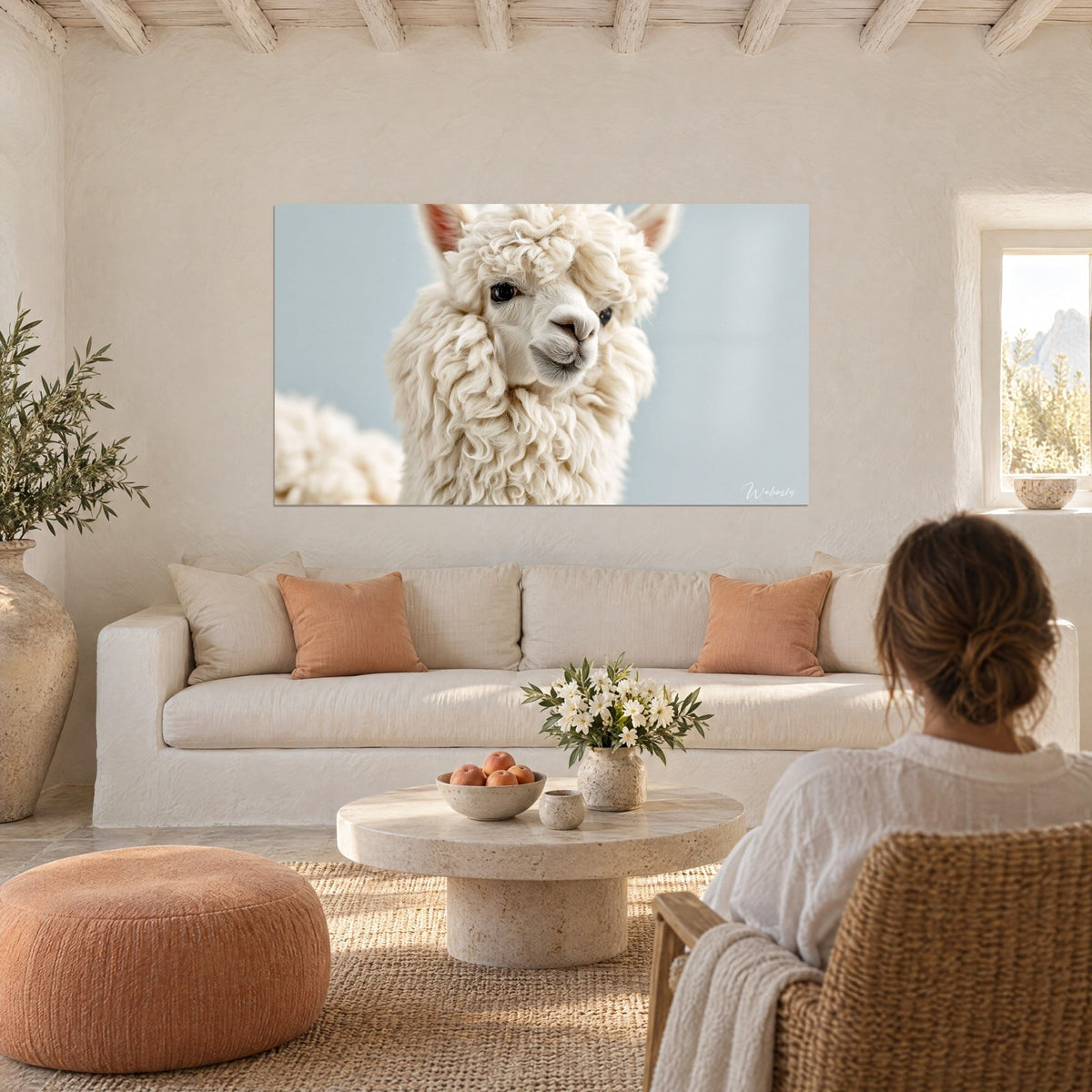 Gemälde eines Alpakas mit cremefarbener, gelockter Wolle, hellblauer Hintergrund, unschuldiger dunkler Blick, über einem Sofa in einem hellen Wohnzimmer