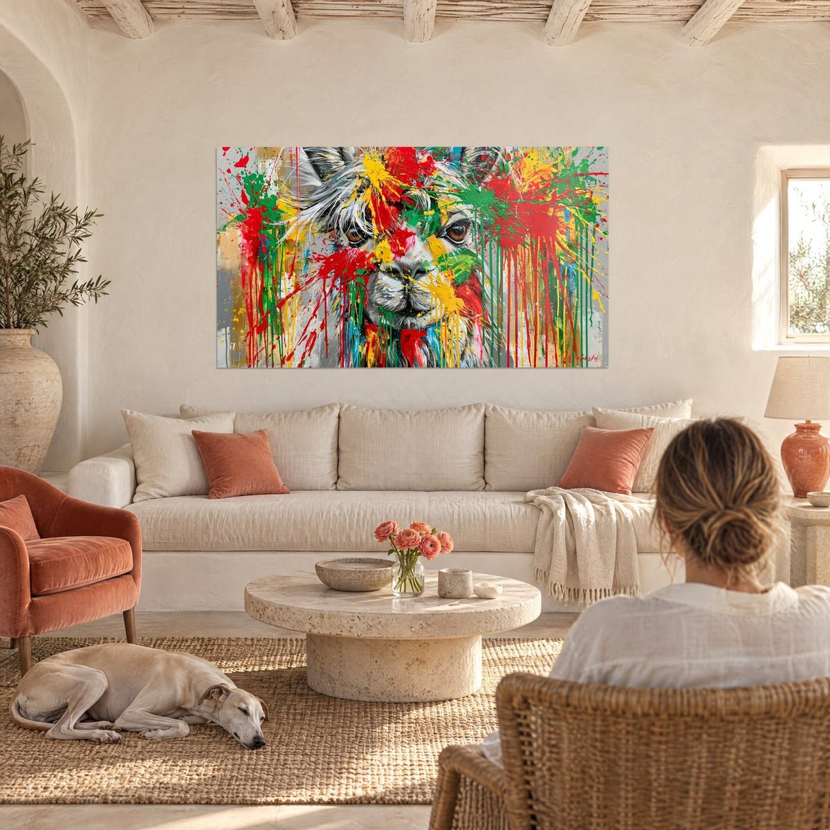 Quadro di alpaca schizzata di rosso, verde e giallo, sguardo bruno, lana grigia, sopra un divano in un soggiorno luminoso