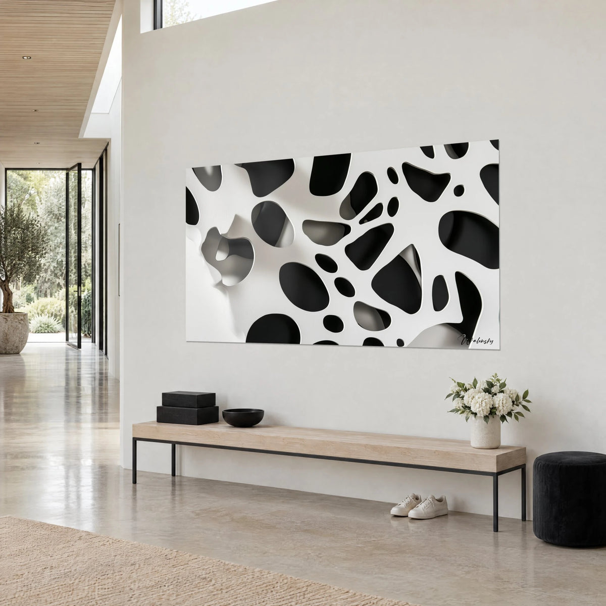 Tableau pièce murale ajourée en relief, taches d'encre noire sur fond blanc crème, vue de trois-quarts, banc en bois clair et bouquet blanc