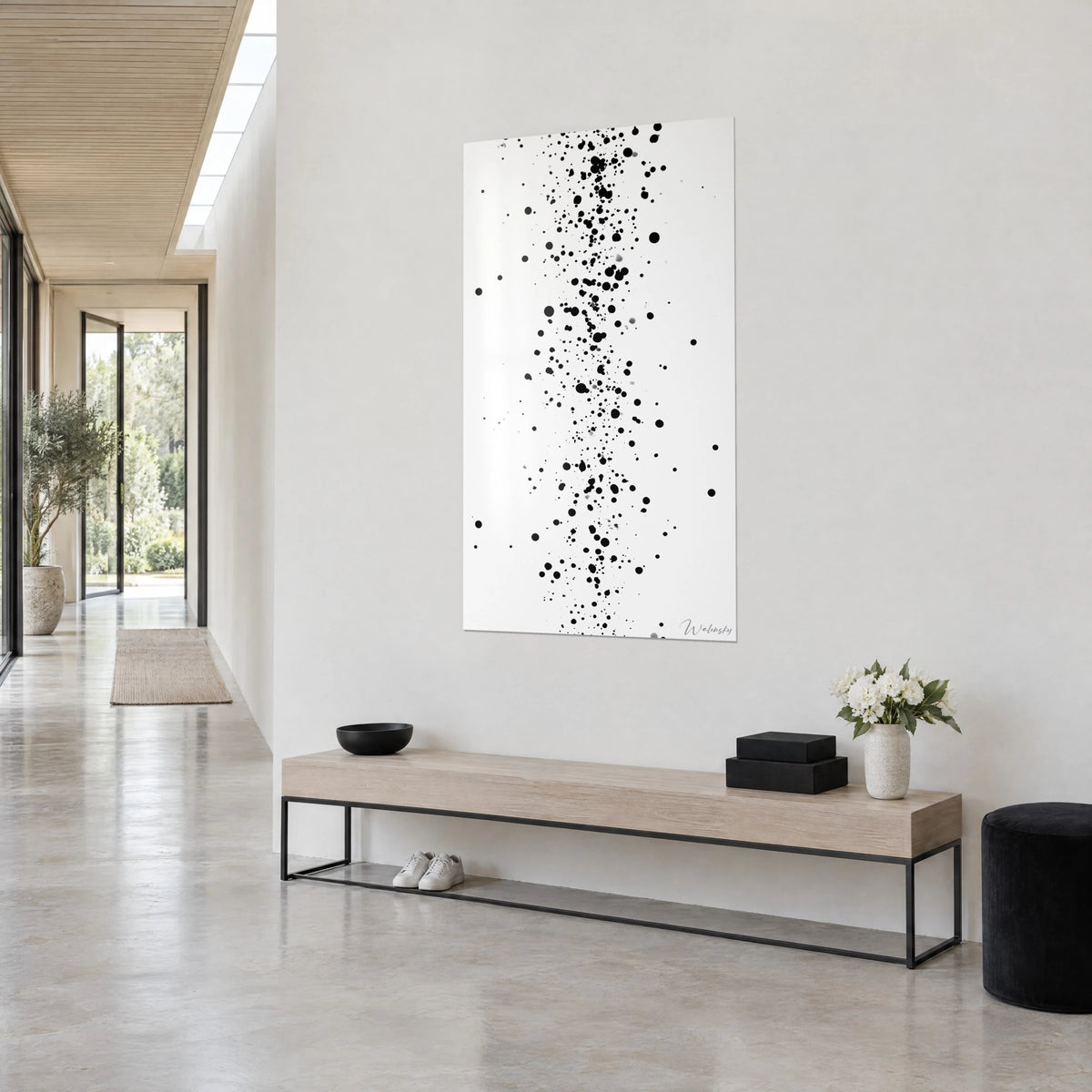 Gemälde mit schwarzen Farbspritzern in vertikalem Streifen auf reinem Weiß, hellgraue Wand, Konsole aus hellem Holz und weiße Blumen
