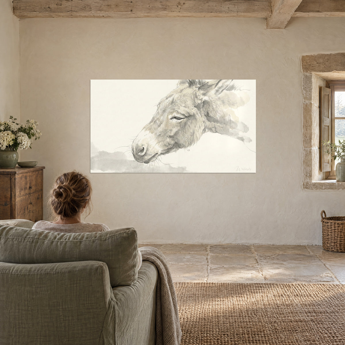 Wall art peaceful donkey in sepia and pale grey wash, ear raised, sage green armchair facing the lime-washed wall of a stone living room