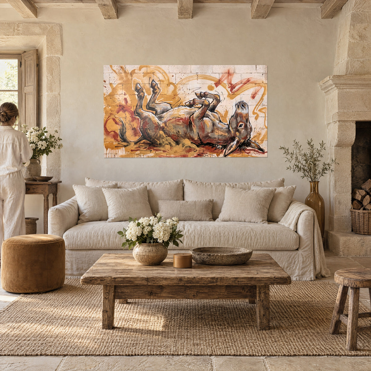 Tableau âne renversé sur le dos, sabots en l'air, pelage brun et ocre sur mur grunge, au-dessus d'un canapé dans un salon lumineux