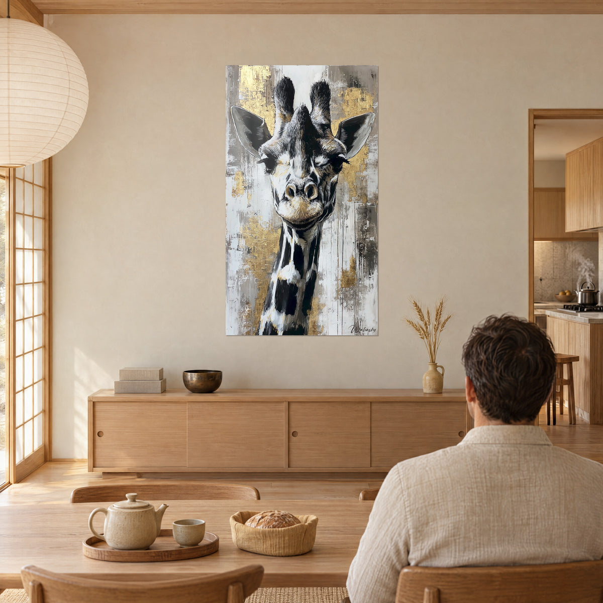 Tableau girafe souriante aux grandes oreilles grises, taches ébène et éclats d'or, homme de dos attablé devant un buffet en bois clair