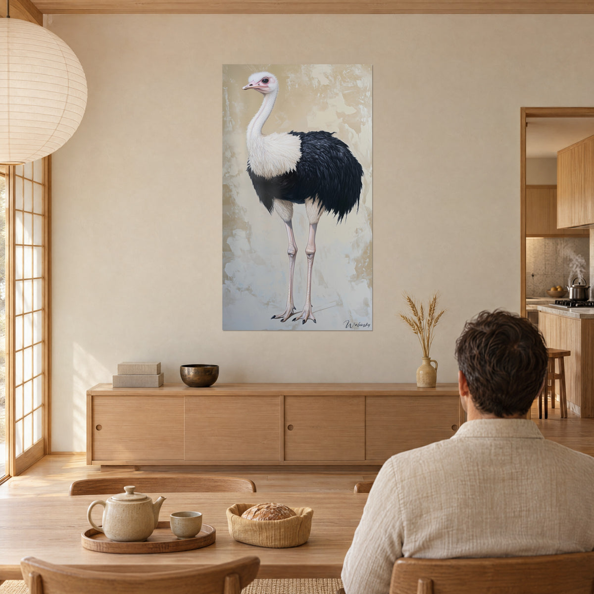 Cuadro avestruz pintada al óleo, plumaje negro profundo, cuello marfil y patas rosadas, frente a una mesa de madera clara, ambiente japandi