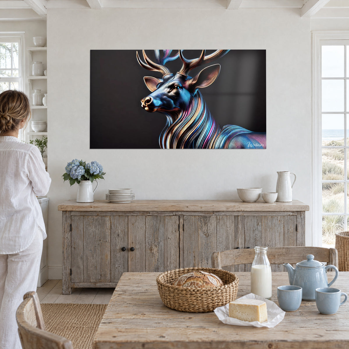 Tableau cerf sculptural aux ramures dorées et pelage nacré bleu et violet, accroché au mur blanc d'une salle à manger de bord de mer