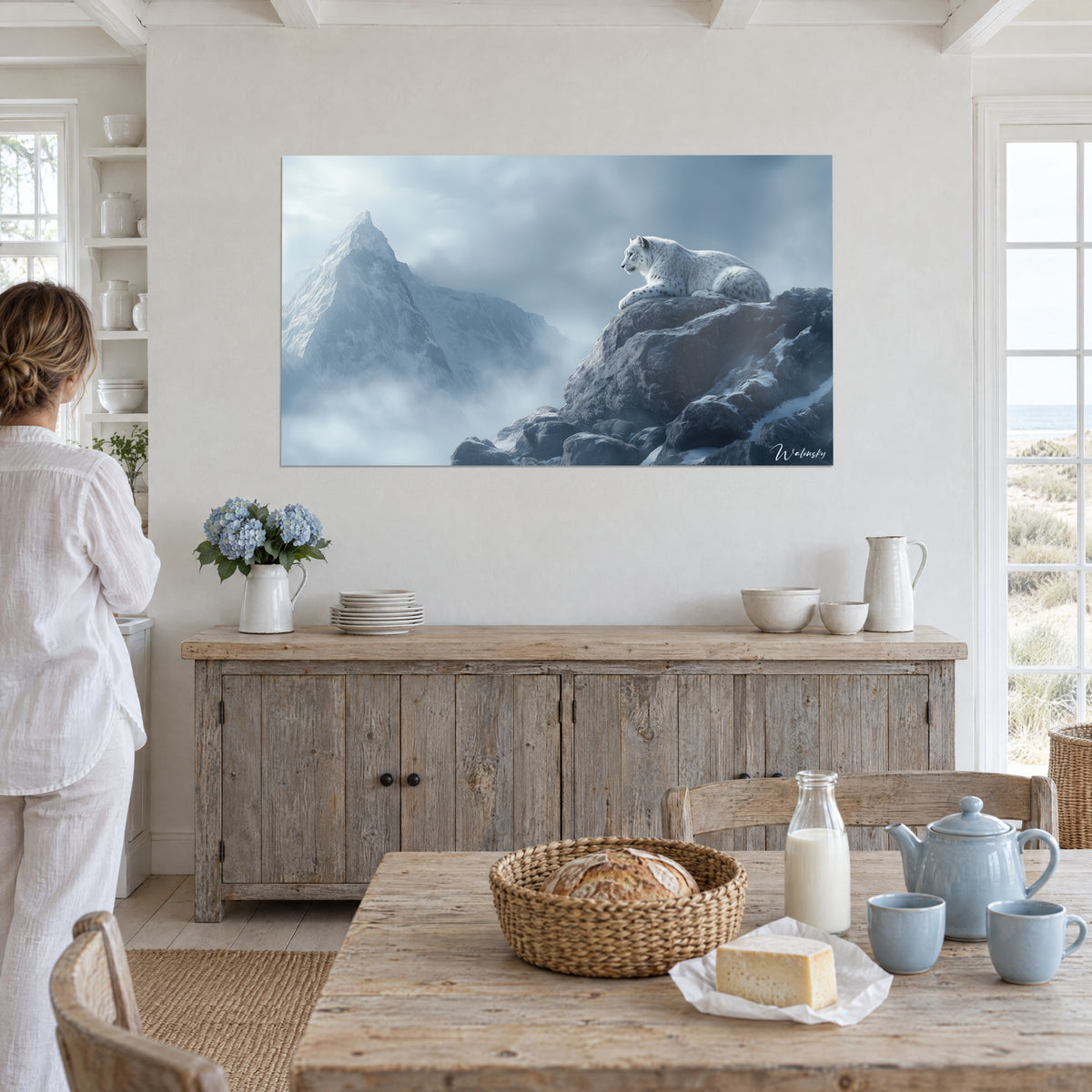 Cuadro de un leopardo de montaña tumbado frente a una cumbre escarchada, tonos azul glaciar y gris perla, en una habitación blanca cerca de las dunas