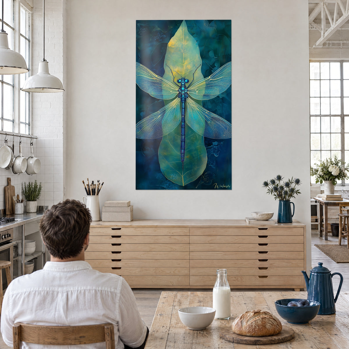 Schilderij libel die transparante water- en blauwgroene vleugels spreidt, een man van achteren aan tafel voor een buffet van licht hout