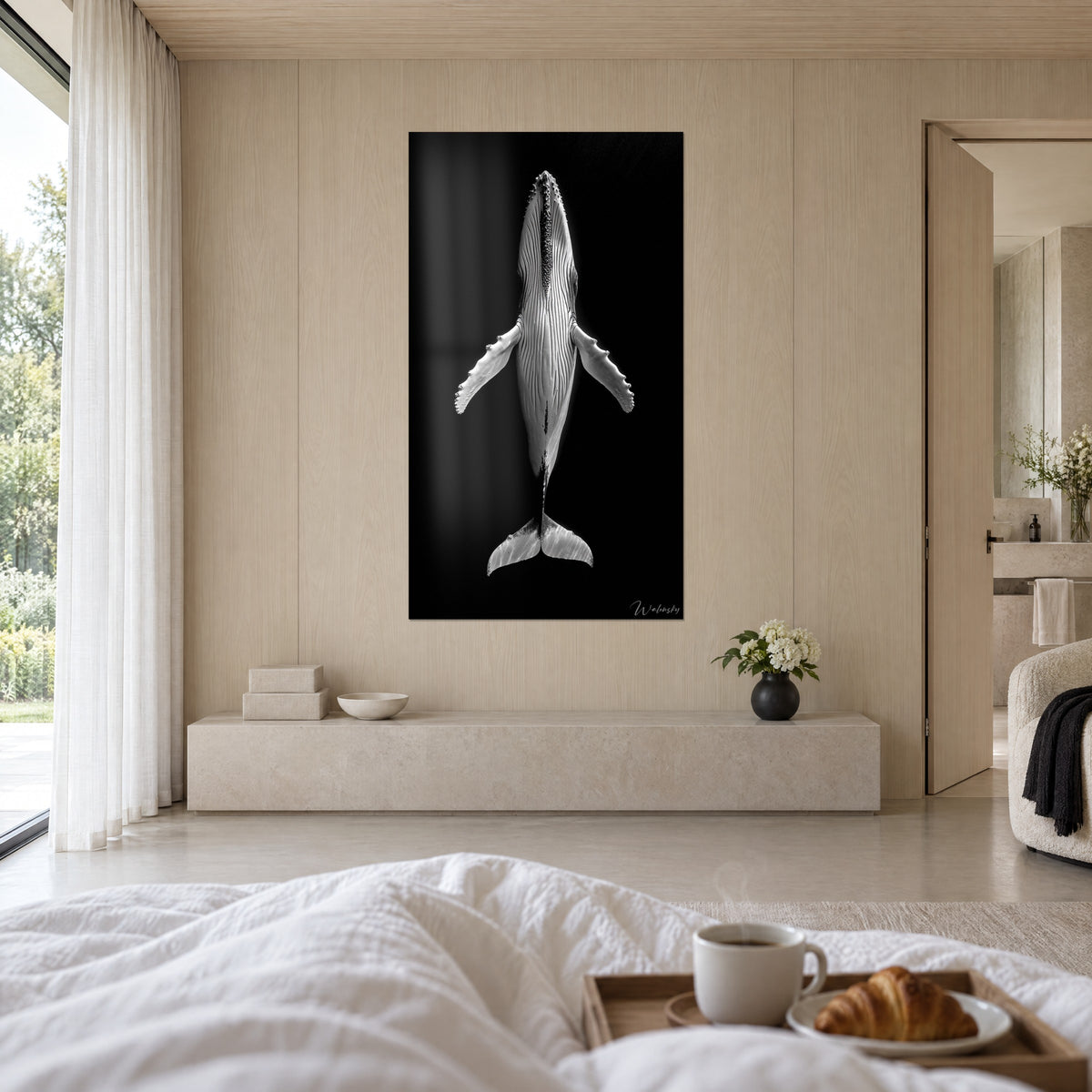 Cuadro gigante mamífero marino en marfil y negro, aletas pectorales desplegadas hacia arriba, encima de una cama en un dormitorio luminoso