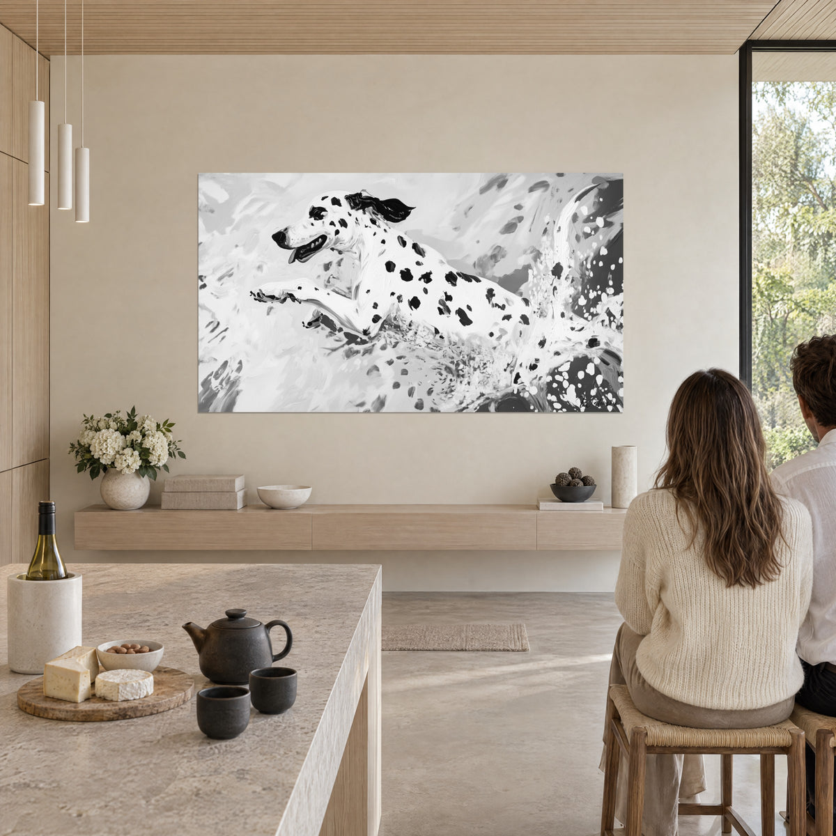 Cuadro de un perro blanco con manchas negras al galope, estallidos de pintura gris antracita, frente a dos personas sentadas en la mesa de la cocina