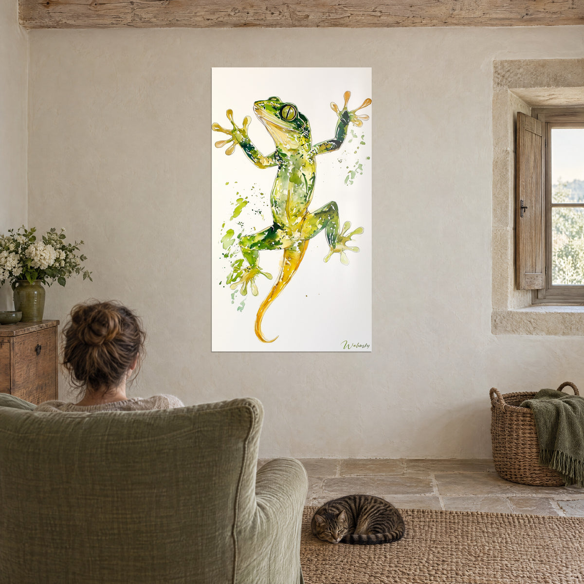 Cuadro de gecko de dedos palmeados en verde y amarillo, fondo blanco crema, con un gato atigrado tumbado en el sillón