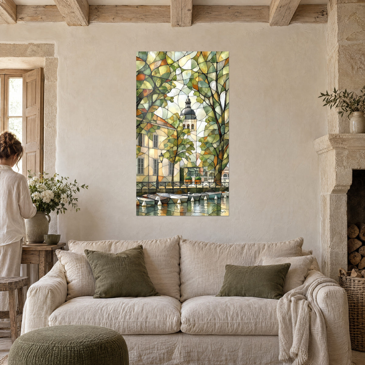 Tableau clocher à dôme gris dans un vitrail de feuillages verts et ocre, barques blanches sur l'eau, au-dessus d'un canapé dans un salon lumineux