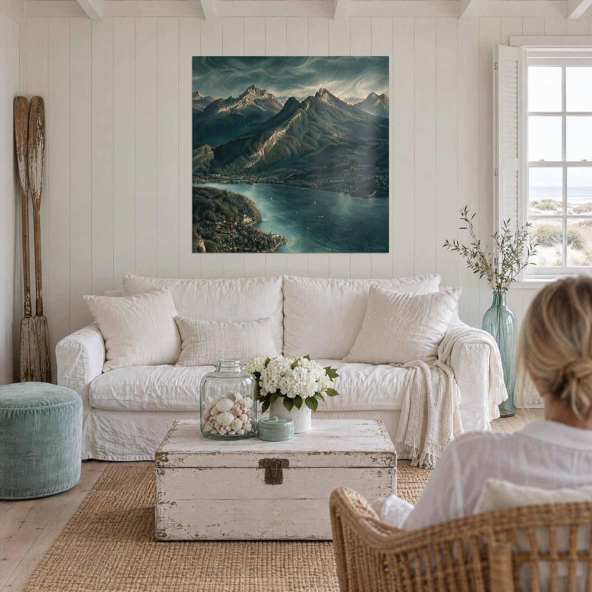 Tableau lac turquoise cerné de crêtes vert sombre, ciel tourbillonnant, voiliers blancs, au-dessus d'un canapé dans un salon lumineux