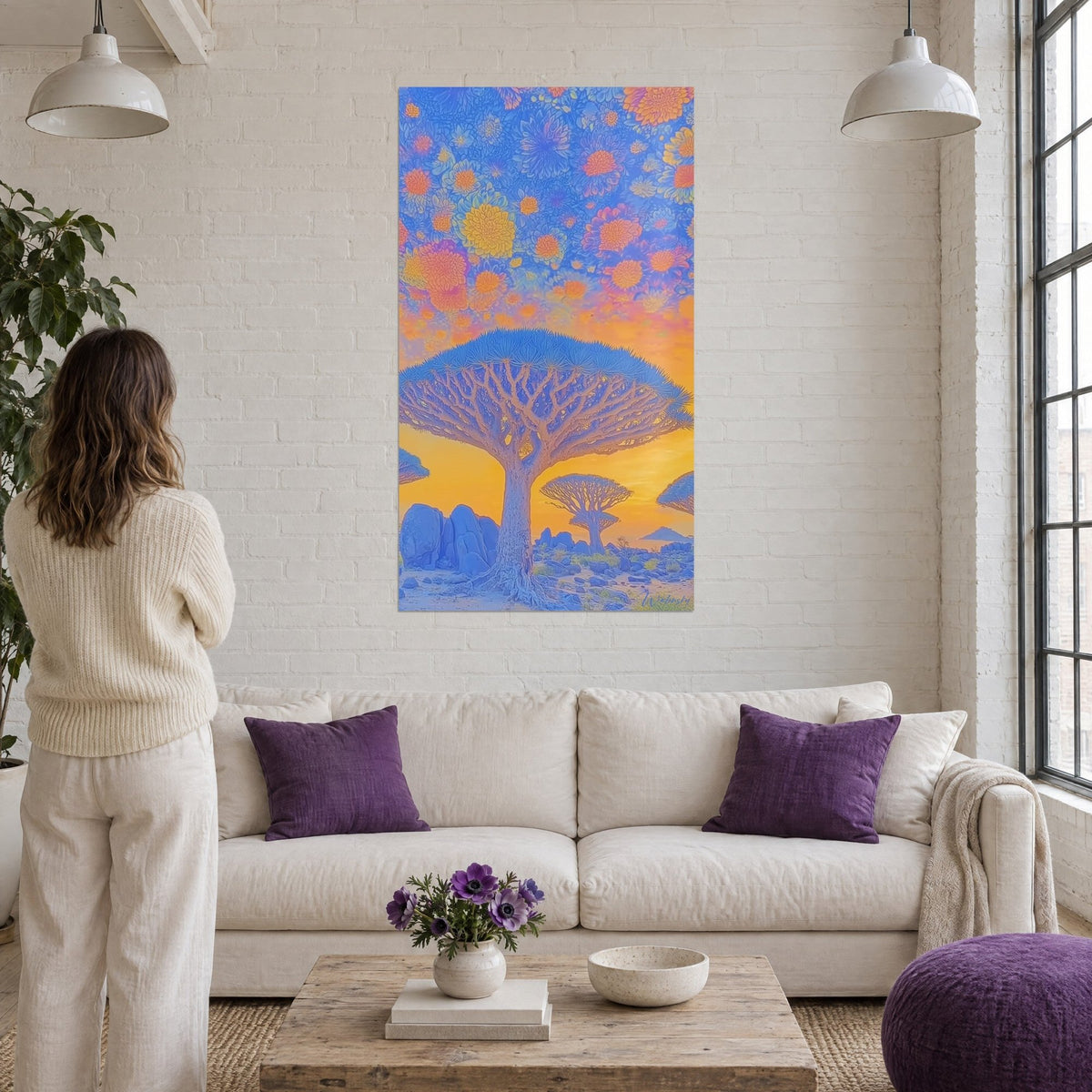 Wall art dragon tree with a blue canopy under a sky of orange and yellow flowers, above a sofa in a bright living room