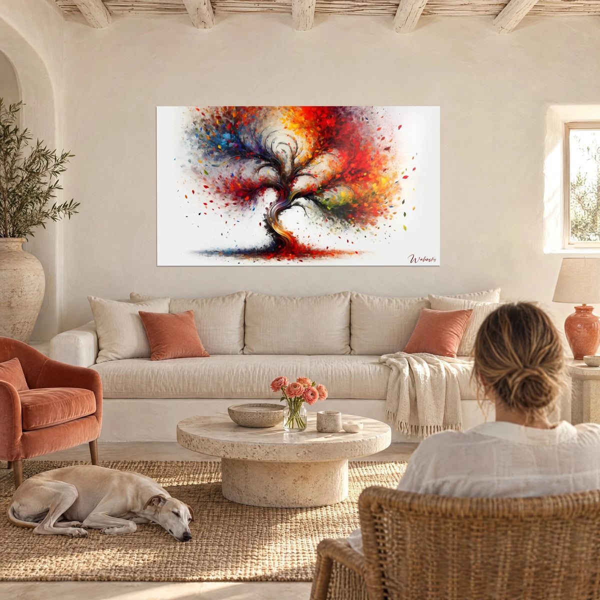 Wall art flamboyant tree with red and orange leaves, a woman seen from behind and a greyhound, above a sofa in a bright living room