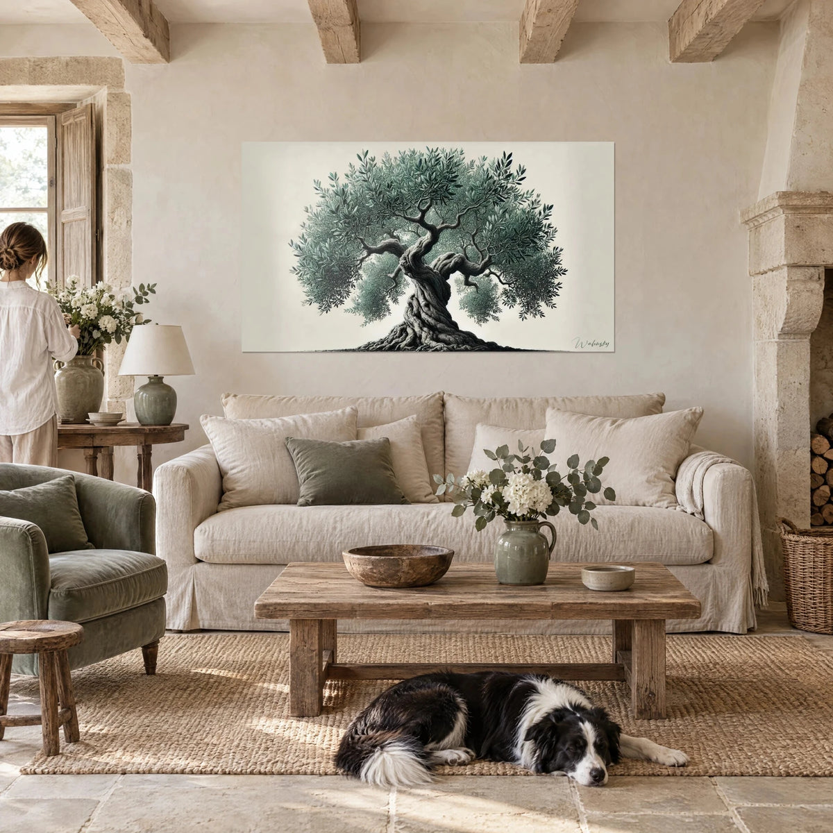 Wall art centuries-old olive tree with grey-green foliage and twisted grey trunk, black and white collie lying down, above a sofa in a bright living room