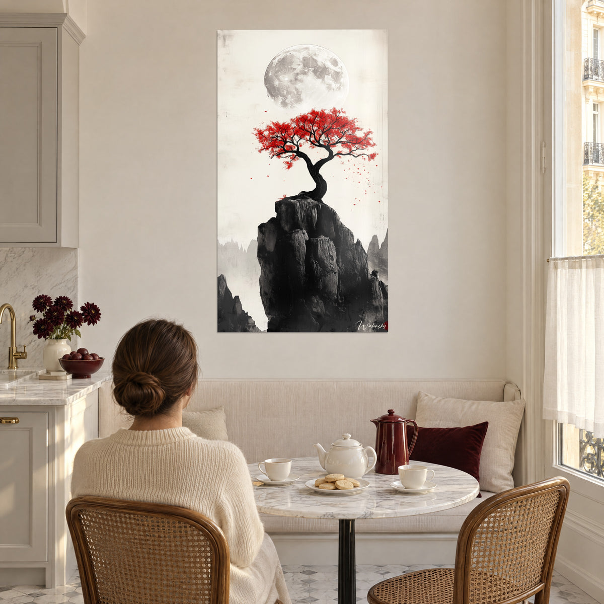 Cuadro bonsái rojo sangre sobre roca negra, luna gris arriba, fondo marfil, rincón de comedor de una cocina, mujer de espaldas