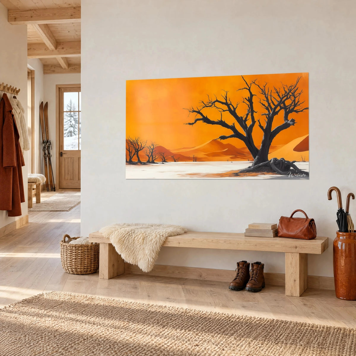 Gemälde vertrockneter Baum vor orangefarbenem Himmel und weißer Ebene, an einer Wand im Eingangsbereich eines Chalets aus hellem Holz