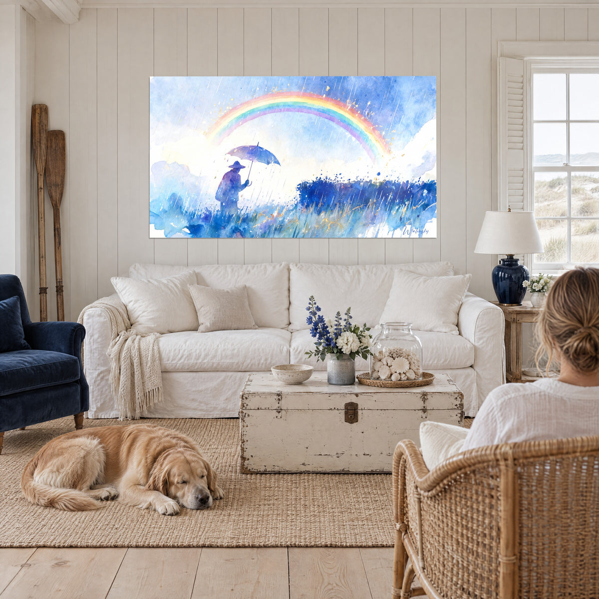 Tableau silhouette au parapluie bleu sous un arc multicolore, ciel azur et or, au-dessus d'un canapé dans un salon lumineux