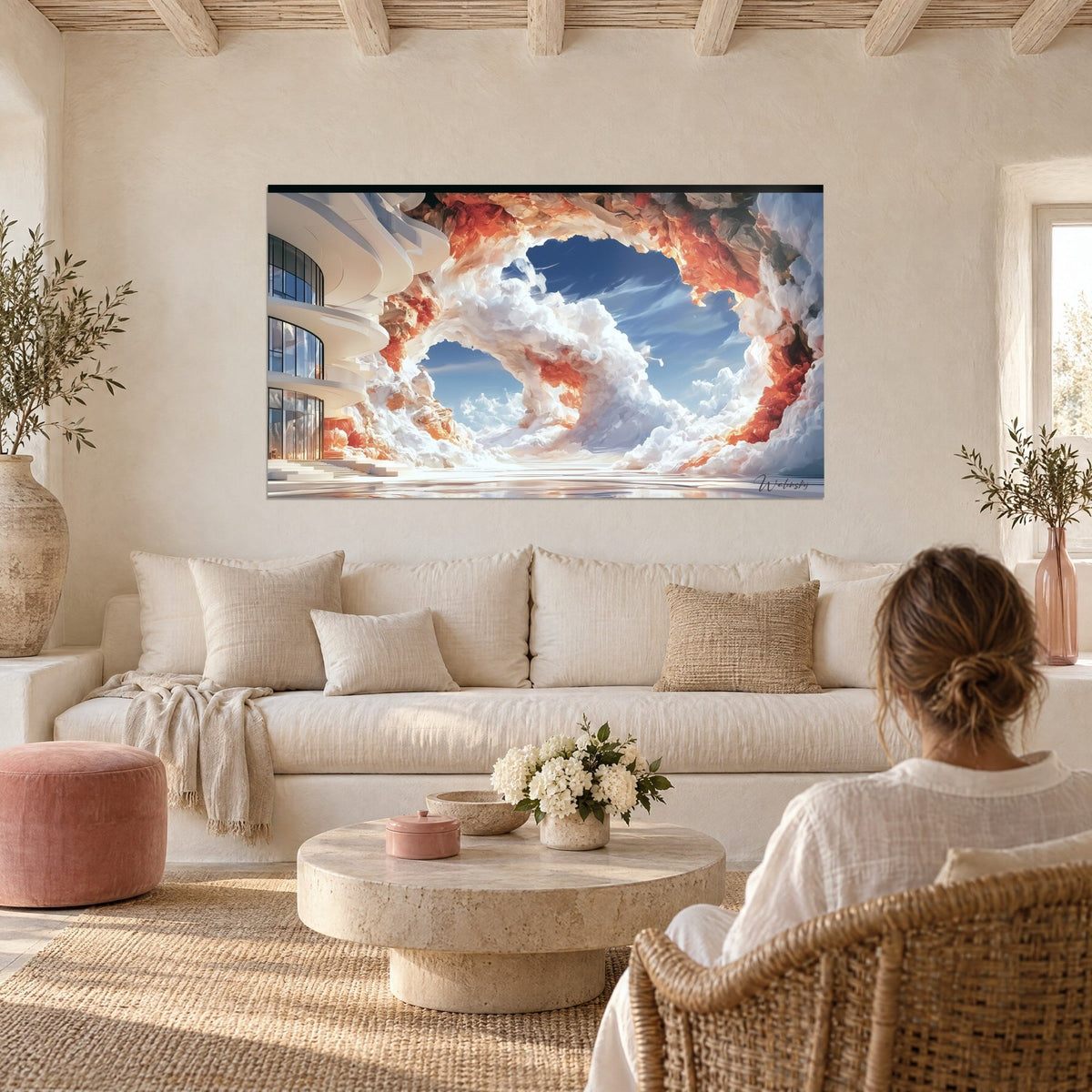Tableau arche de nuages blancs et orangés encadrant un ciel bleu, une femme de dos, au-dessus d'un canapé dans un salon lumineux