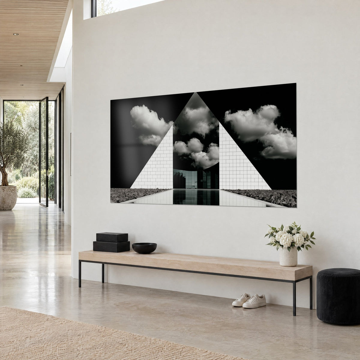 Cuadro de un triángulo de ladrillos marfil que se abre a un cielo tormentoso en blanco y negro, estanque espejo, vista de tres cuartos, pared beige