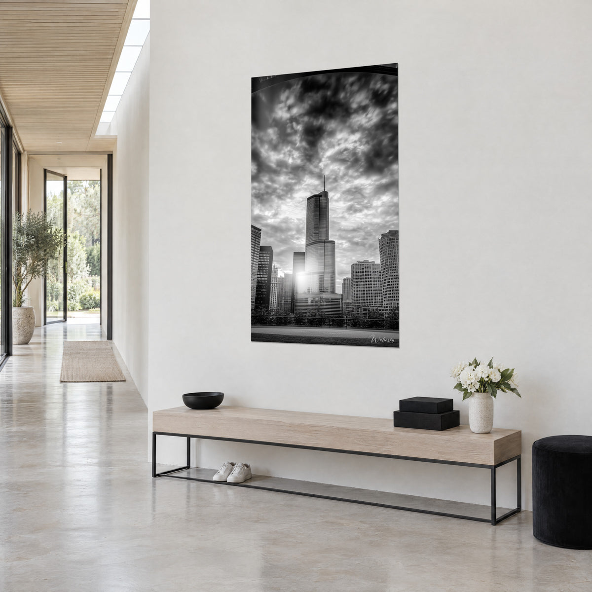 Wall art of a glass tower from a low angle, charcoal grey sky and brilliant white, shot three-quarter view against a light hallway wall