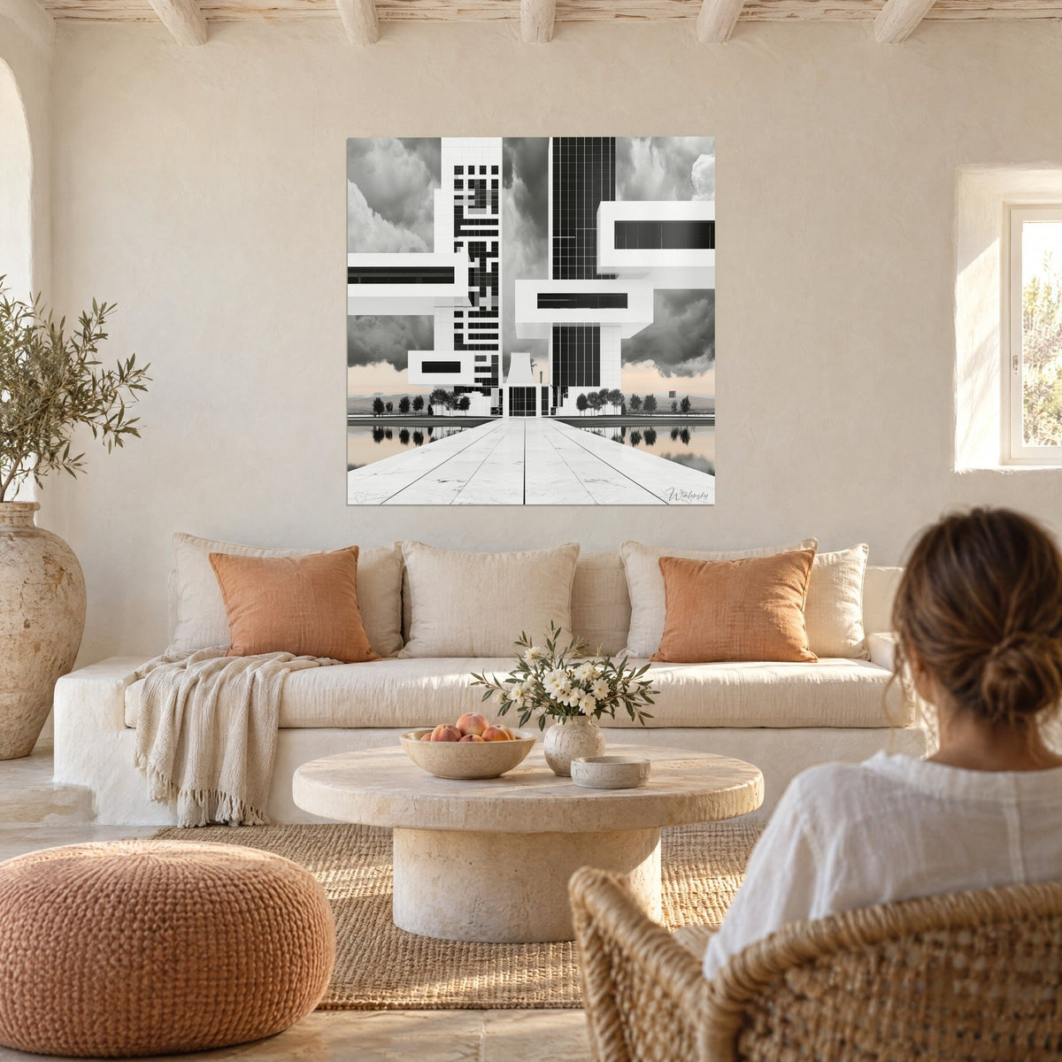 Tableau gratte-ciel blanc aux blocs anthracite sous nuages gris, reflets rosés sur l'eau, au-dessus d'un canapé dans un salon lumineux