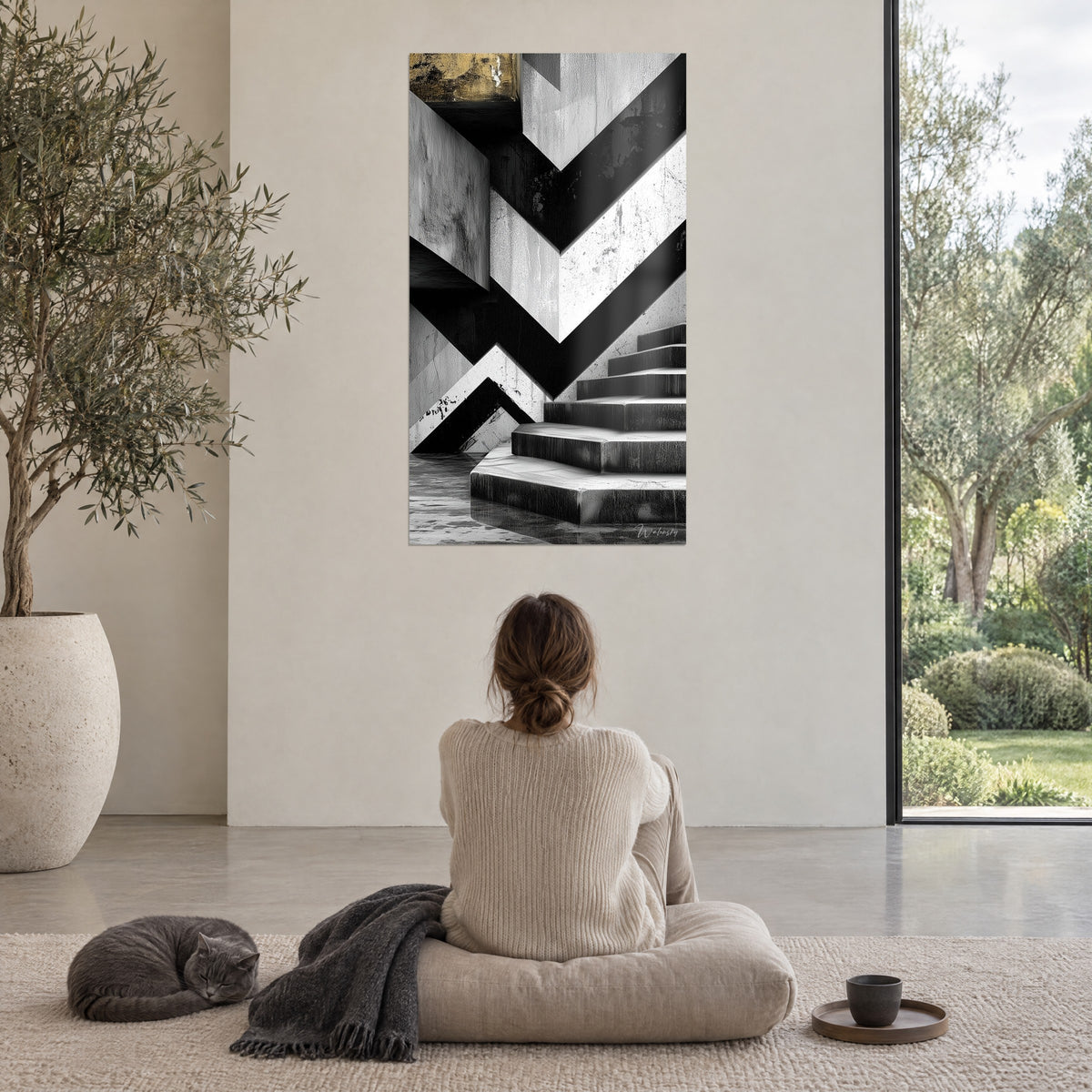 Tableau géométrie de béton noir et blanc, marches et pointe dorée, une femme de dos assise au sol, chat shorthair près d'un plaid