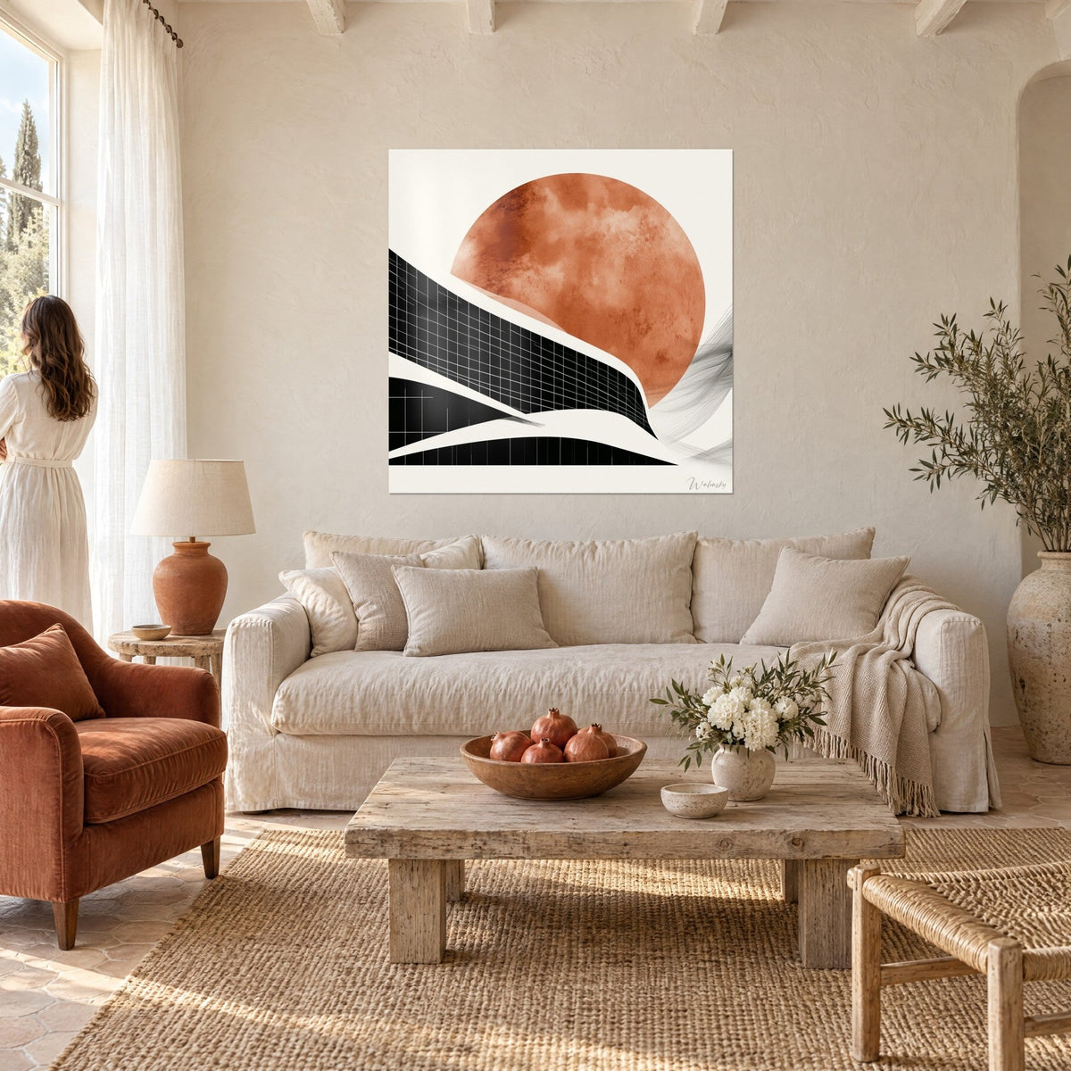 Quadro con disco terracotta sopra una facciata a quadretti neri, crema e ruggine, sopra un divano in un soggiorno luminoso