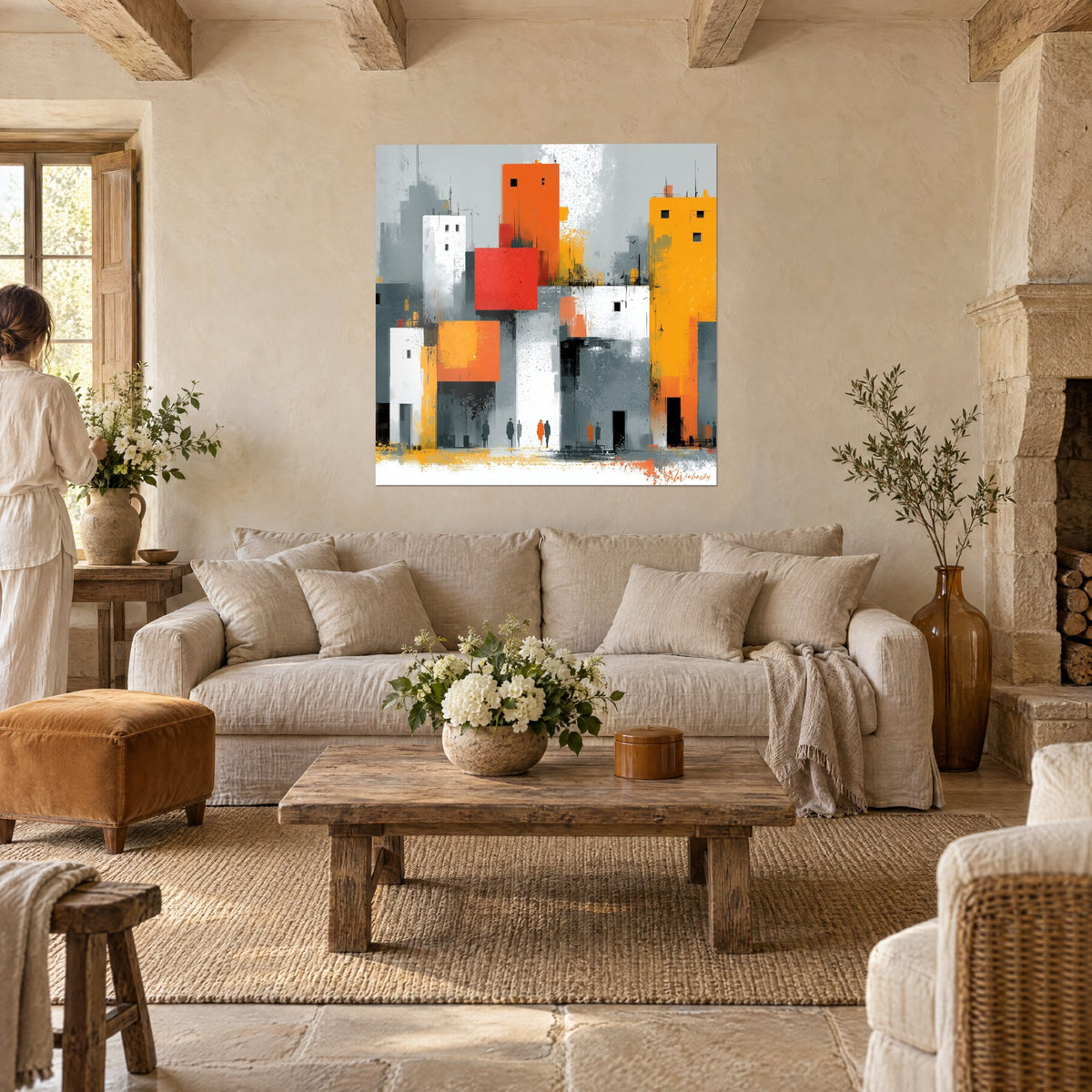 Tableau tours carrées orange et jaune éclaboussées de gris, deux silhouettes de dos, au-dessus d'un canapé dans un salon lumineux