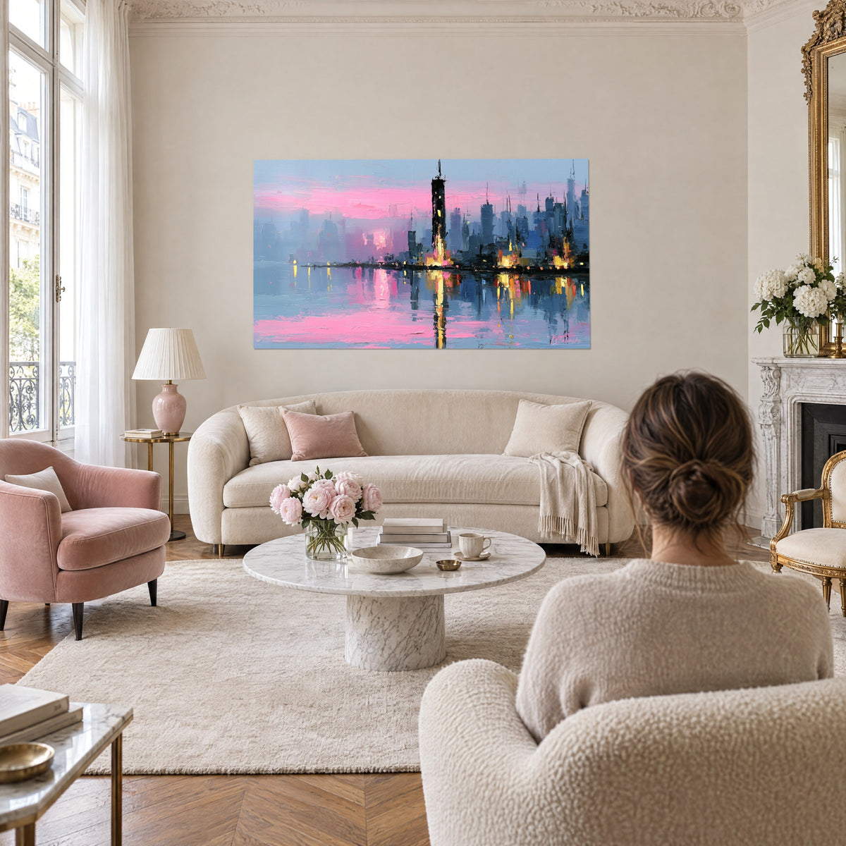 Wall art pink and blue city skyline, black tower lit in yellow, two people seen from behind, above a sofa in a bright living room