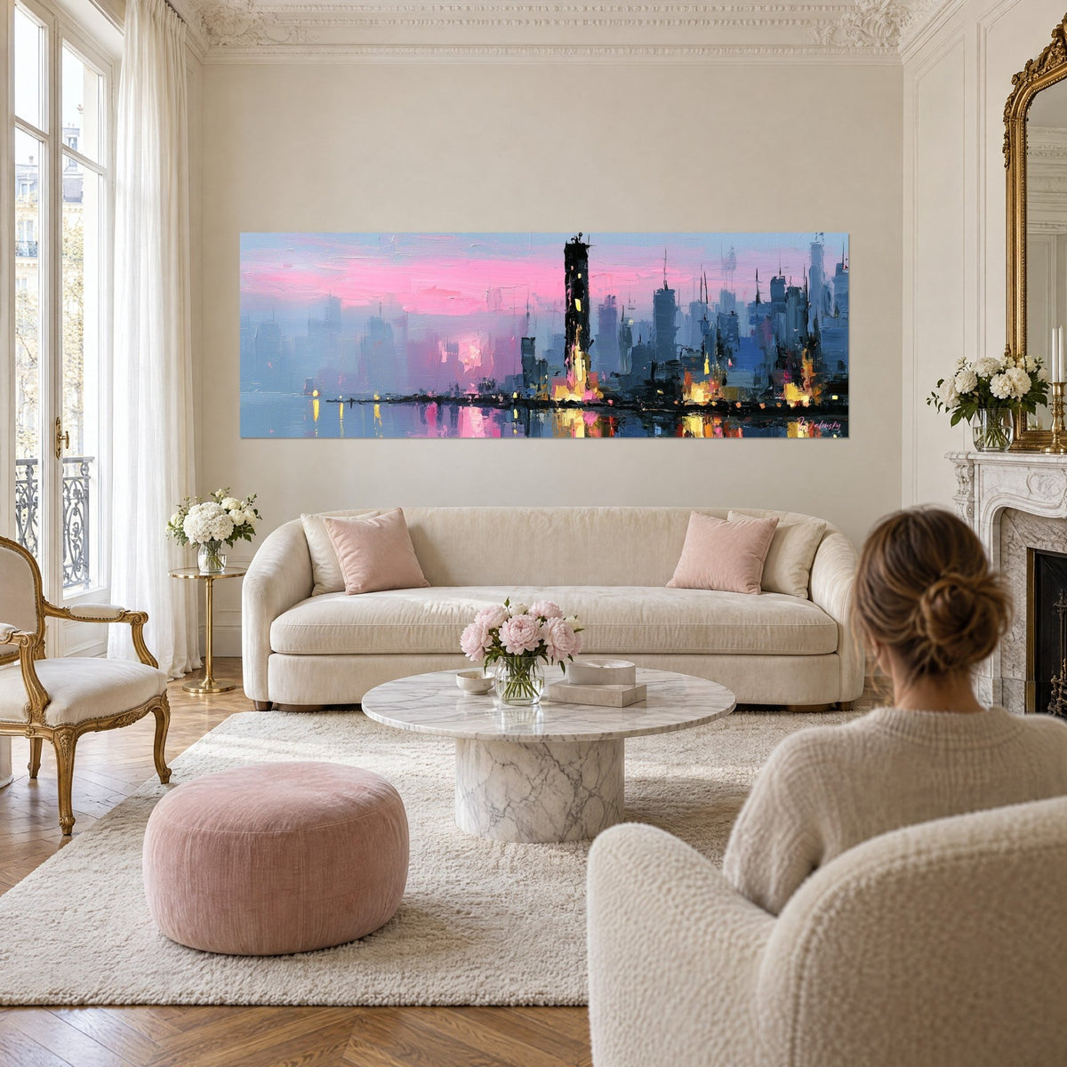 Tableau skyline urbaine aux nuées roses et gratte-ciel bleu ardoise, reflets dorés sur l'eau, au-dessus d'un canapé dans un salon lumineux