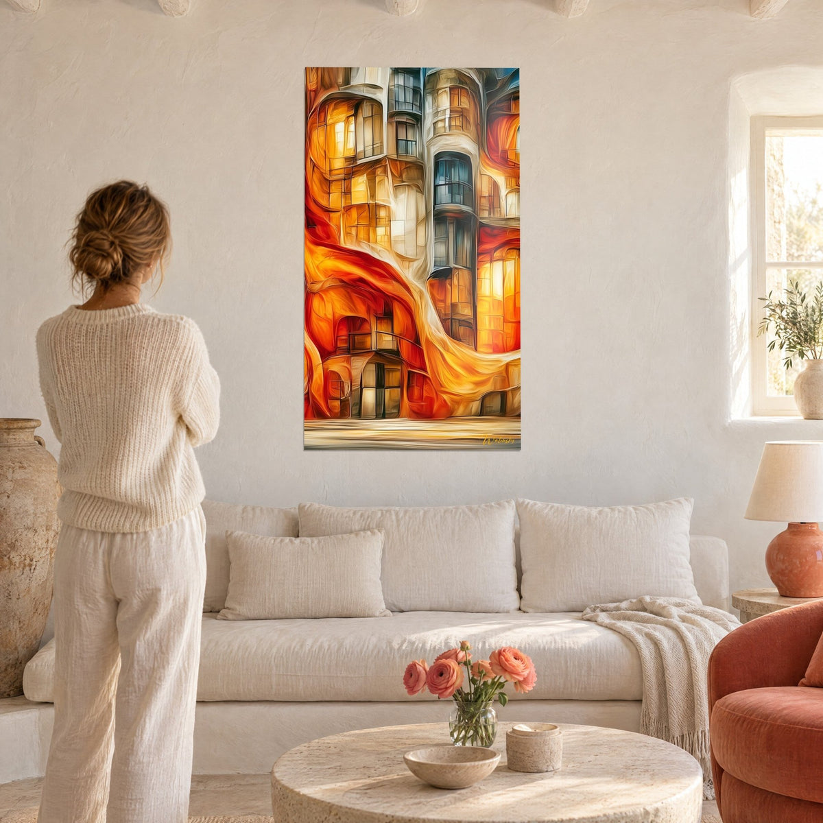Tableau façade ondulante aux balcons vitrés ambrés, rouge vif et orange, femme de dos, au-dessus d'un canapé dans un salon lumineux