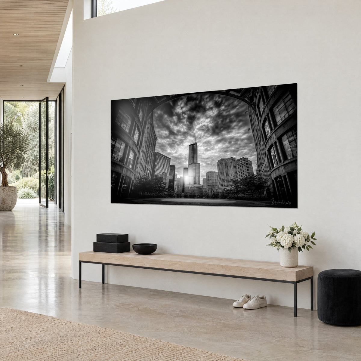 Tableau tour vitrée perçant les nuages sombres, façades courbes noires et ciel blanc cendré, vue de trois-quarts sur un mur clair de maison d'architecte