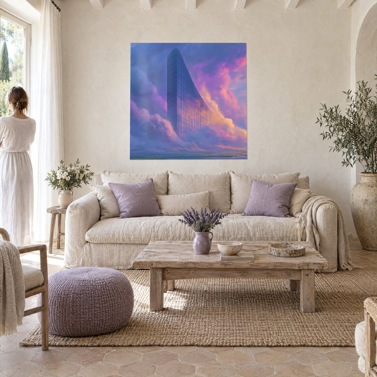 Tableau gratte-ciel de verre bleu nuit surgissant de nuages rose et pêche, femme de dos, au-dessus d'un canapé dans un salon lumineux