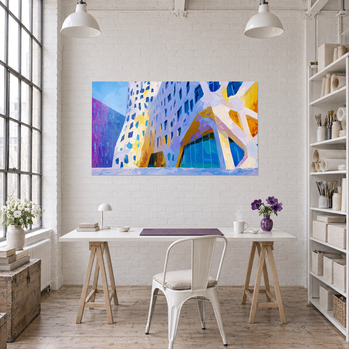 Cuadro arquitectura deconstruida en blanco nacarado, aperturas azul real y naranja, frente a un escritorio de madera clara con flores moradas en un loft
