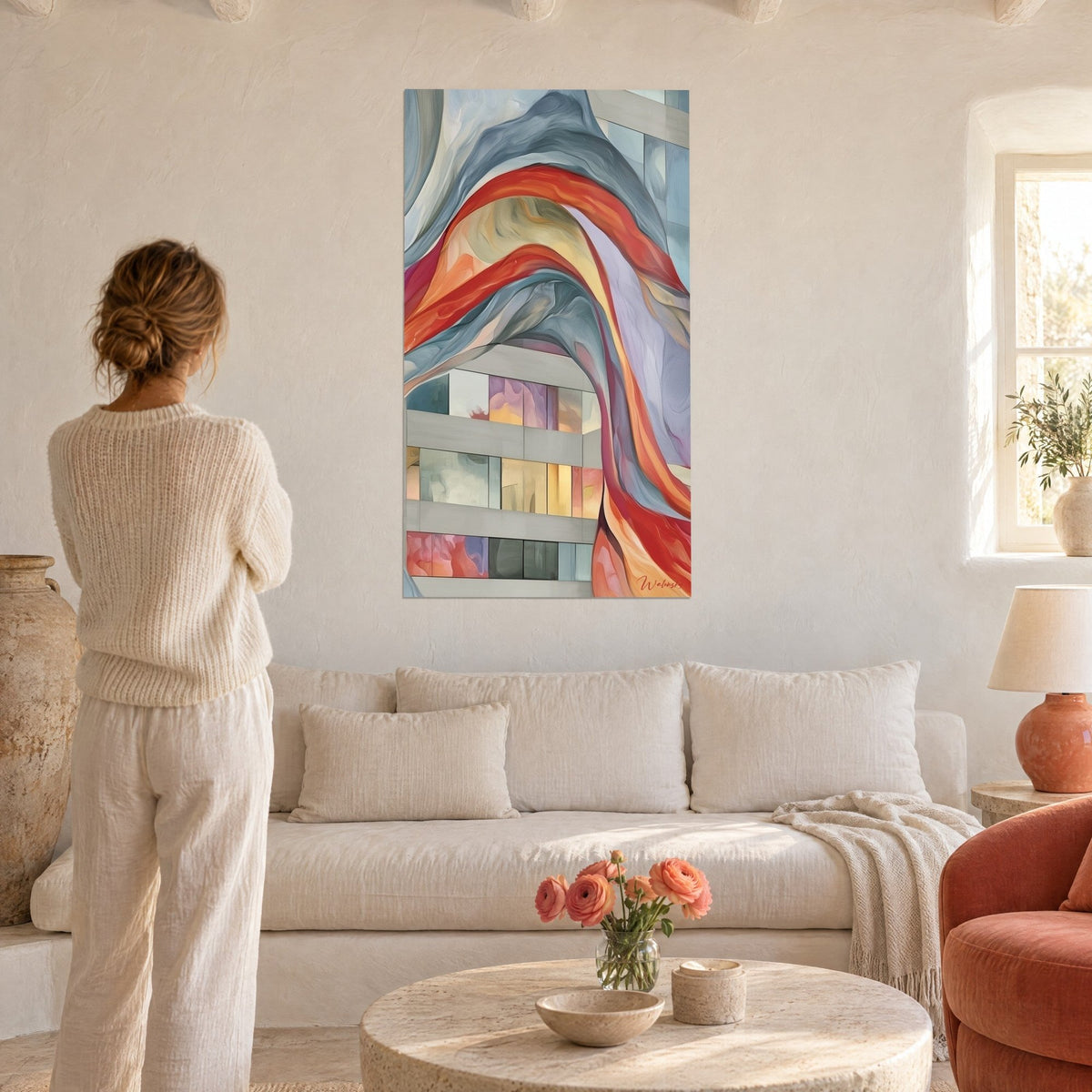 Tableau voile rouge ondulant sur façade grise aux vitres pastel, femme de dos, au-dessus d'un canapé dans un salon lumineux
