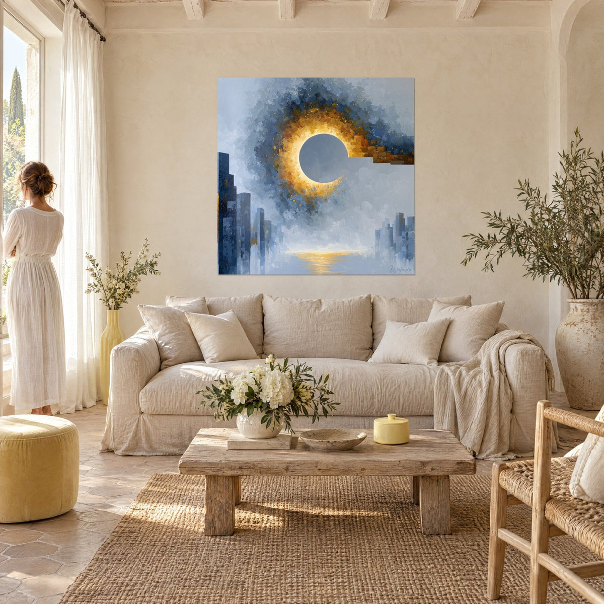 Tableau éclipse dorée cernée de bleu nuit, tours bleutées en bas, femme en robe blanche de dos, au-dessus d'un canapé dans un salon lumineux