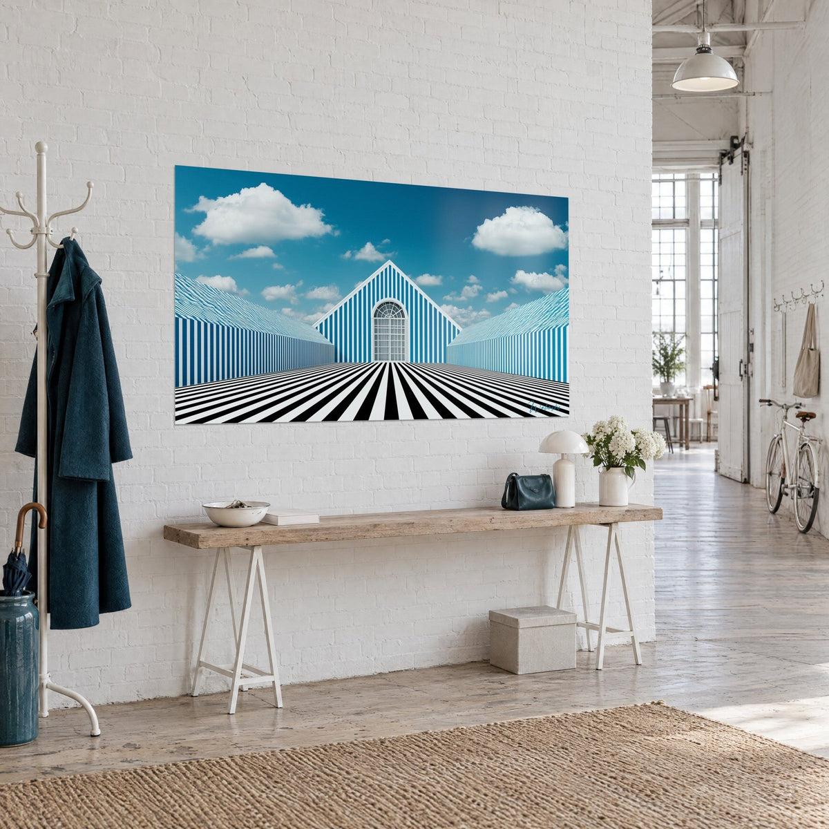 Gemälde mit gestreifter Fassade und großem Rundbogenfenster, blauer Himmel mit weißen Wolken, schwarz-weißer Boden, weiße Ziegelwand im Loft