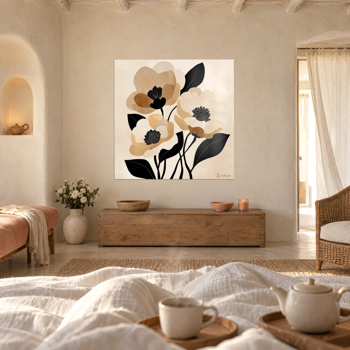 Cuadro anémonas gigantes beige y caramelo con hojas negras recortadas, frente a una cama de lino blanco en un dormitorio luminoso